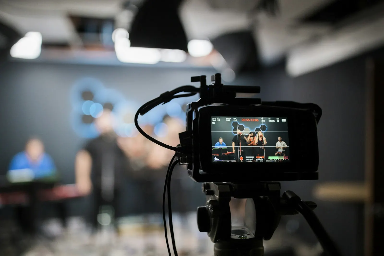 Camera monitor showing a band being recorded in a dark studio